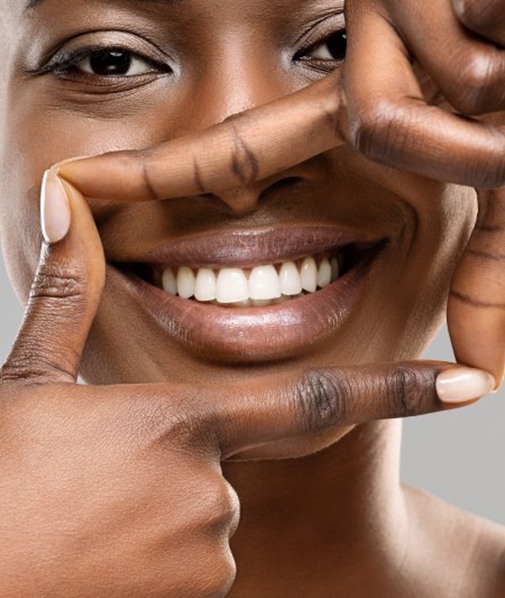 Woman outlining her bright smile with her fingers