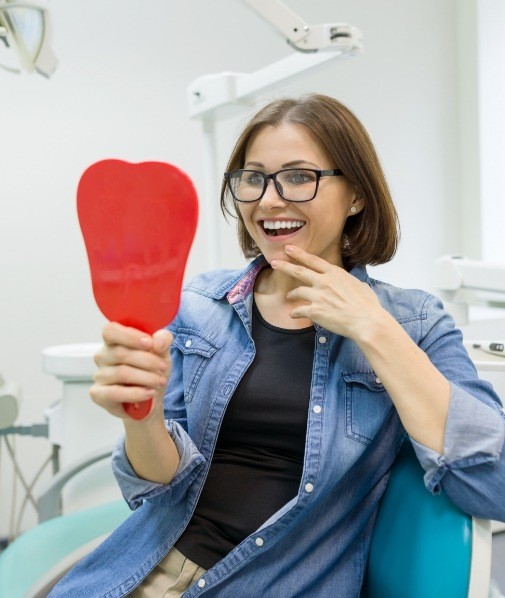 Woman looking at her smile in a mirror