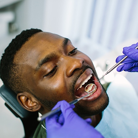 a patient having their teeth examined by a dentist